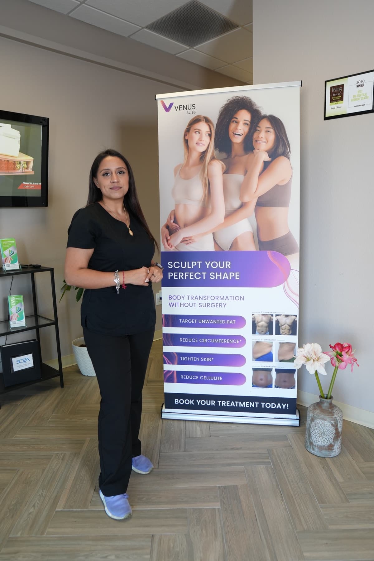 A Soza Clinic team member beside the Venus Bliss body contouring display in Richardson
