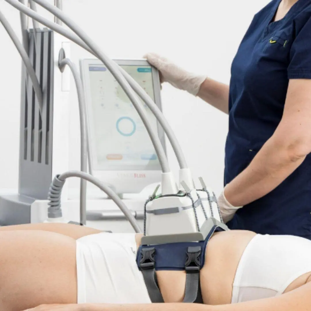 The Venus Bliss console beside a patient with the applicator belt in place